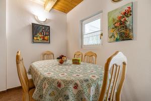 a dining room with a table and chairs and a window at Ladybug House With Whirlpool - Happy Rentals in Fokovci
