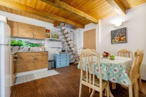 cocina y comedor con mesa y sillas en Ladybug House With Whirlpool en Fokovci
