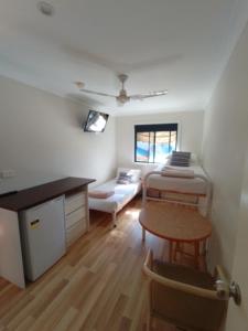 a room with a bed and a table and a couch at T's Resort & Motel in Port Macquarie