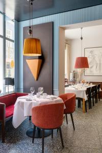 een restaurant met witte tafels en rode stoelen bij B&B Belle de Nuit in Oostende