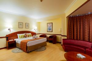 a hotel room with a bed and a couch at City Palace Hotel in Dubai