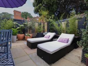 a patio with two couches on a patio at Tower End Cottage in Woodbridge