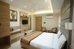 una camera d'albergo con letto e TV di HOTEL THE VENUE a Dhanbād