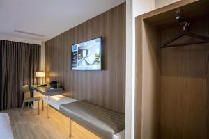um quarto de hotel com uma cama, uma secretária e uma televisão em AC Hotel by Marriott Birmingham em Birmingham
