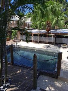 a pool with a rope around it with palm trees at Le ti bali Chambre in Saint-Leu