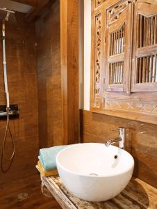 baño con lavabo blanco en una encimera de madera en Le ti bali Chambre, en Saint-Leu