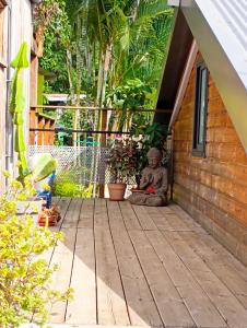 una estatua sentada en el porche de una casa en Le ti bali Chambre, en Saint-Leu