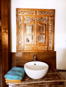 a bathroom with a white bowl sink on a wooden counter at Le ti bali Chambre in Saint-Leu