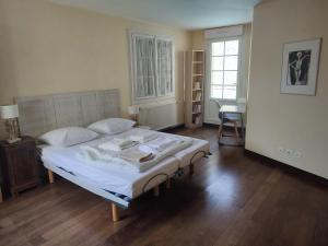 een slaapkamer met een bed, een tafel en een bureau bij Les Arums - Maison de Vacances in Saint-Xandre