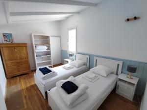 een slaapkamer met 2 bedden, een bank en een raam bij Les Arums - Maison de Vacances in Saint-Xandre