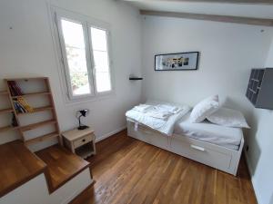 een kleine slaapkamer met een bed en een raam bij Les Arums - Maison de Vacances in Saint-Xandre