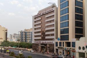 a tall building on a city street with cars at City Palace Hotel in Dubai