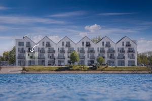 una representación de un gran edificio de apartamentos desde el agua en Segler Nest, en Olpenitz