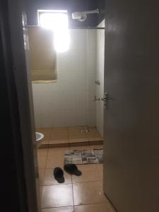 a bathroom with a toilet and a light on a door at Family-Friendly Home in Nairobi