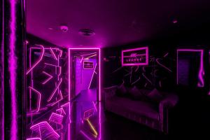 a purple room with a couch and a neon sign at City Palace Hotel in Dubai