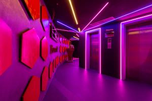 a room with pink lights and pictures on the wall at City Palace Hotel in Dubai