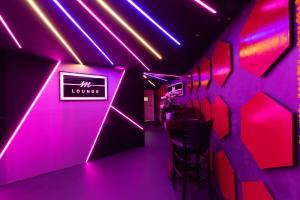 a room with pink lights and a sign on the wall at City Palace Hotel in Dubai