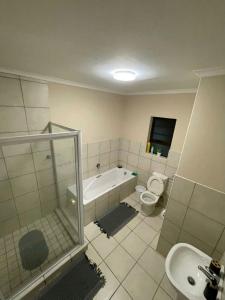 een badkamer met een bad, een toilet en een wastafel bij Cleo's Corner in East London