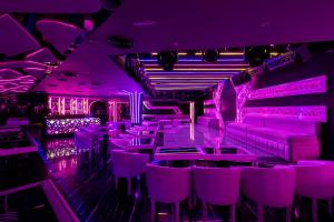 a purple room with purple chairs and tables at City Palace Hotel in Dubai