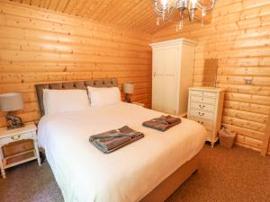 une chambre avec un lit dans une cabane en rondins dans l'établissement 64 Acorn Lodge Kenwick Park, à Louth