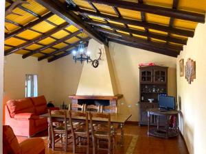 sala de estar con mesa y chimenea en Finca Villa Coral, en Cazalla de la Sierra