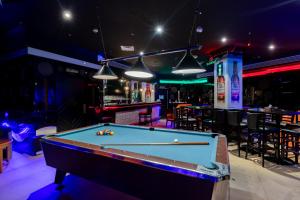 a pool table in a bar with lights at City Palace Hotel in Dubai