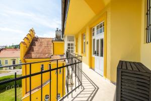 a balcony of a yellow building with a white door at Albizia-Apartments in Baden
