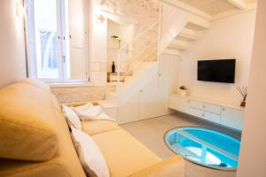 un soggiorno con divano e tavolo in vetro di Il Melograno Suite Apartment a Martina Franca