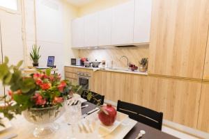 una cucina con tavolo e vaso di fiori di Il Melograno Suite Apartment a Martina Franca