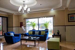 a living room with blue furniture and a large window at Hotel Milan Panama in Panama City