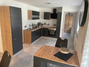 a kitchen with black cabinets and a wooden table at Ferienwohnung an der Linde in Bischofsheim an der Rhön