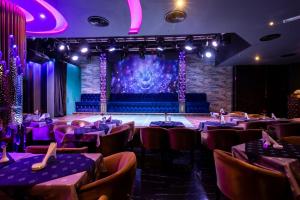 a dining room with tables and chairs and a stage at City Palace Hotel in Dubai +37 photos