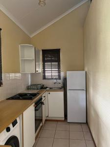 a kitchen with a white refrigerator and a stove at Pendleberry Holiday Resort - Unit 41 in Bela-Bela