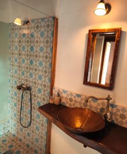 a bathroom with a copper sink and a mirror at Verde de Viscri in Viscri