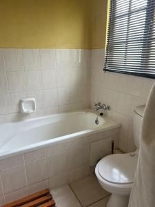 a bathroom with a white tub and a toilet at Pendleberry Holiday Resort - Unit 41 in Bela-Bela