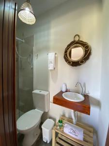 a bathroom with a toilet and a sink and a mirror at Chalé Entre as Pedras in Serra de São Bento