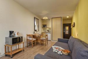 sala de estar con sofá y cocina en Chamonix Sud - Bâtiment F 400 - Happy Rentals, en Chamonix-Mont-Blanc