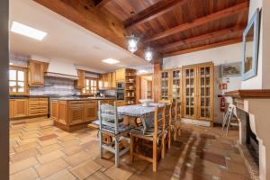 una cocina con armarios de madera, mesa y sillas en Villa Marjals, en Muro