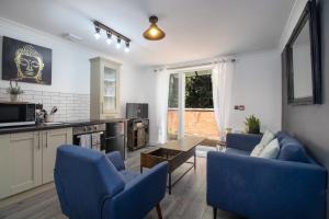 sala de estar con sillas azules y mesa en No5, One-Bedroom Apartment, Willowbrook House, en Bedworth