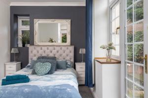 a bedroom with a blue and white bed and a mirror at No5, One-Bedroom Apartment, Willowbrook House in Bedworth