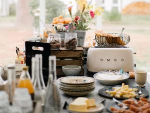 a table topped with plates of food and cheese at Demeures de Campagne Parc du Coudray - Barbizon in Le Coudray-Montceaux