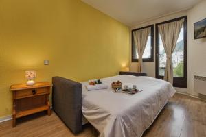een slaapkamer met een groot bed en een houten tafel bij Chamonix Sud - Bâtiment F 400 - Happy Rentals in Chamonix-Mont-Blanc
