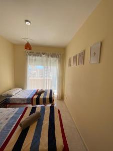 two beds in a room with a window at Fantástico apartamento playa in Cala de Finestrat