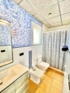 a bathroom with a toilet and a sink and a mirror at Villa Only Adults 2 Pax · Piscina Privada · A/C · WIFI · BBQ in Blanes
