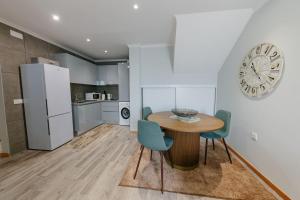 a kitchen with a table and chairs and a clock on the wall at SWEET home I in Caniçal