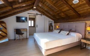 a bedroom with a large bed in a room with wooden ceilings at O Relax do Río - Casa Molino Boutique, con Jardín y Desayuno en Muxía in Muxia +31 photos