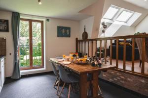 een eetkamer met een houten tafel met stoelen bij Vakantiewoning & Fietslogies V E L O, Tussen Hasselt en Maastricht in Bilzen