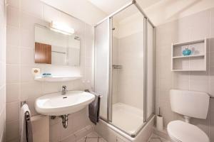 a bathroom with a sink and a shower and a toilet at Apartement Bublitz in Travemünde