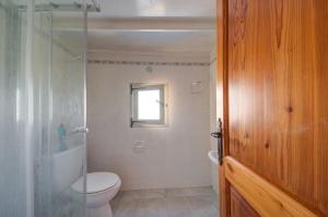 a bathroom with a toilet and a shower and a window at Razzett Warda B&B in Għasri