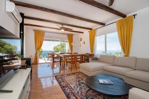 uma sala de estar com um sofá e uma mesa em Villa la Colina with heated pool and jacuzzi em Salobreña